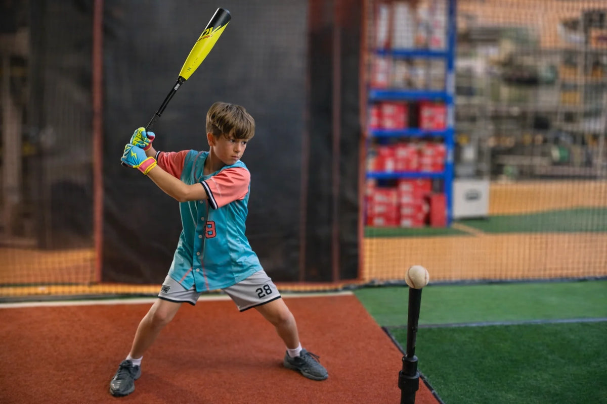 A player taking a swing in the Fieldhouse batting cages